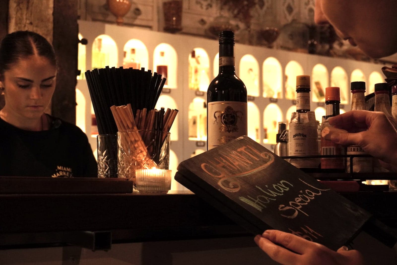 Bar staff holding a chalk menu board reading ‘Italian Special’.