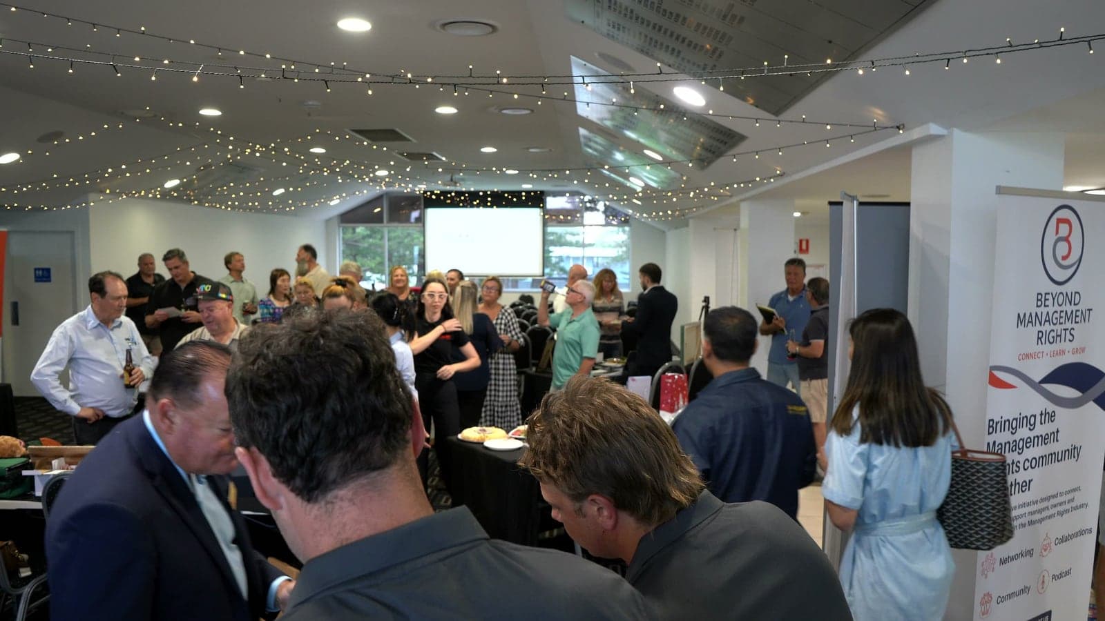Guests networking under festoon lights at the 2025 Beyond Management Rights night.