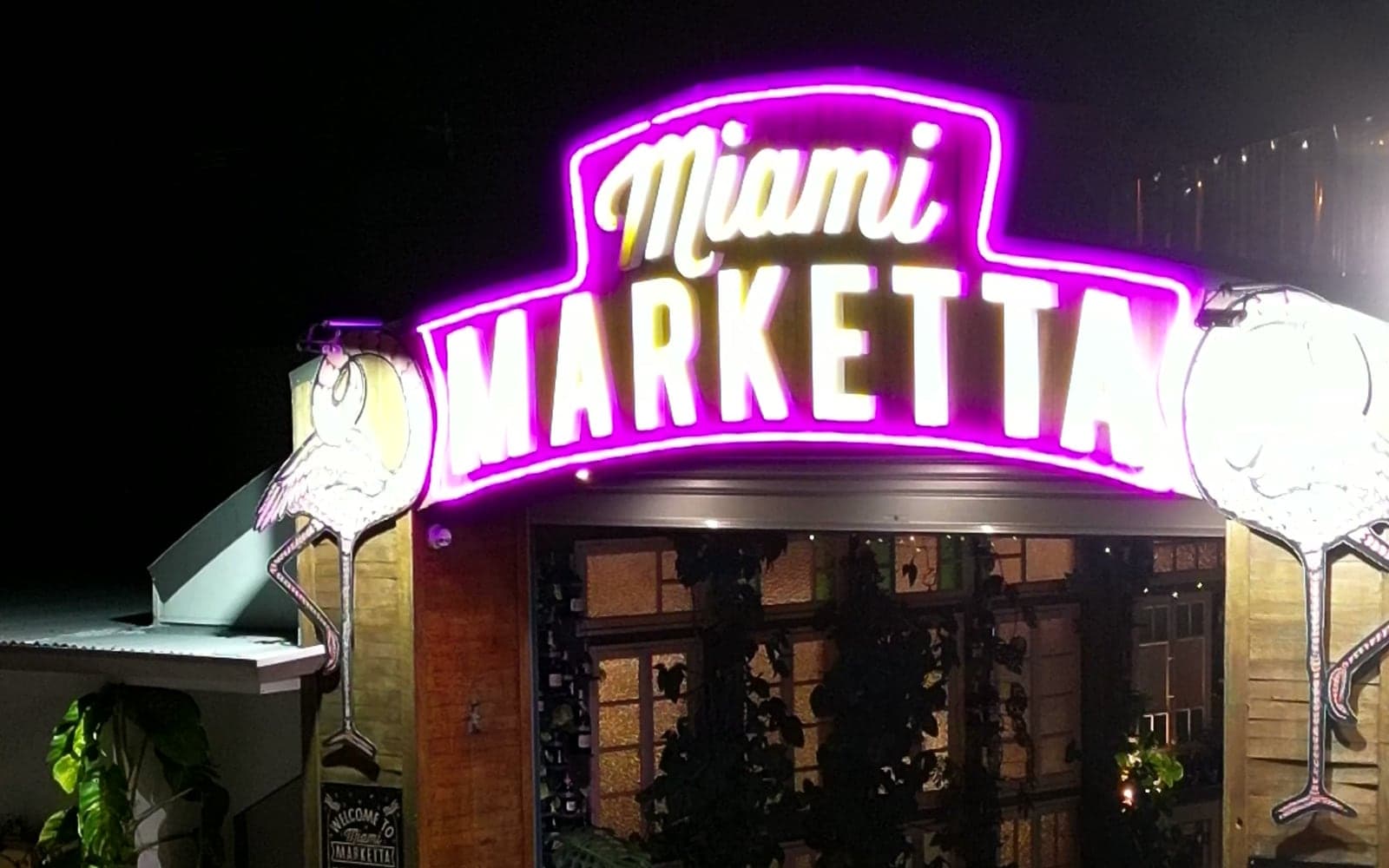 The lit neon archway of Miami Marketta, the 2026 venue, at night.