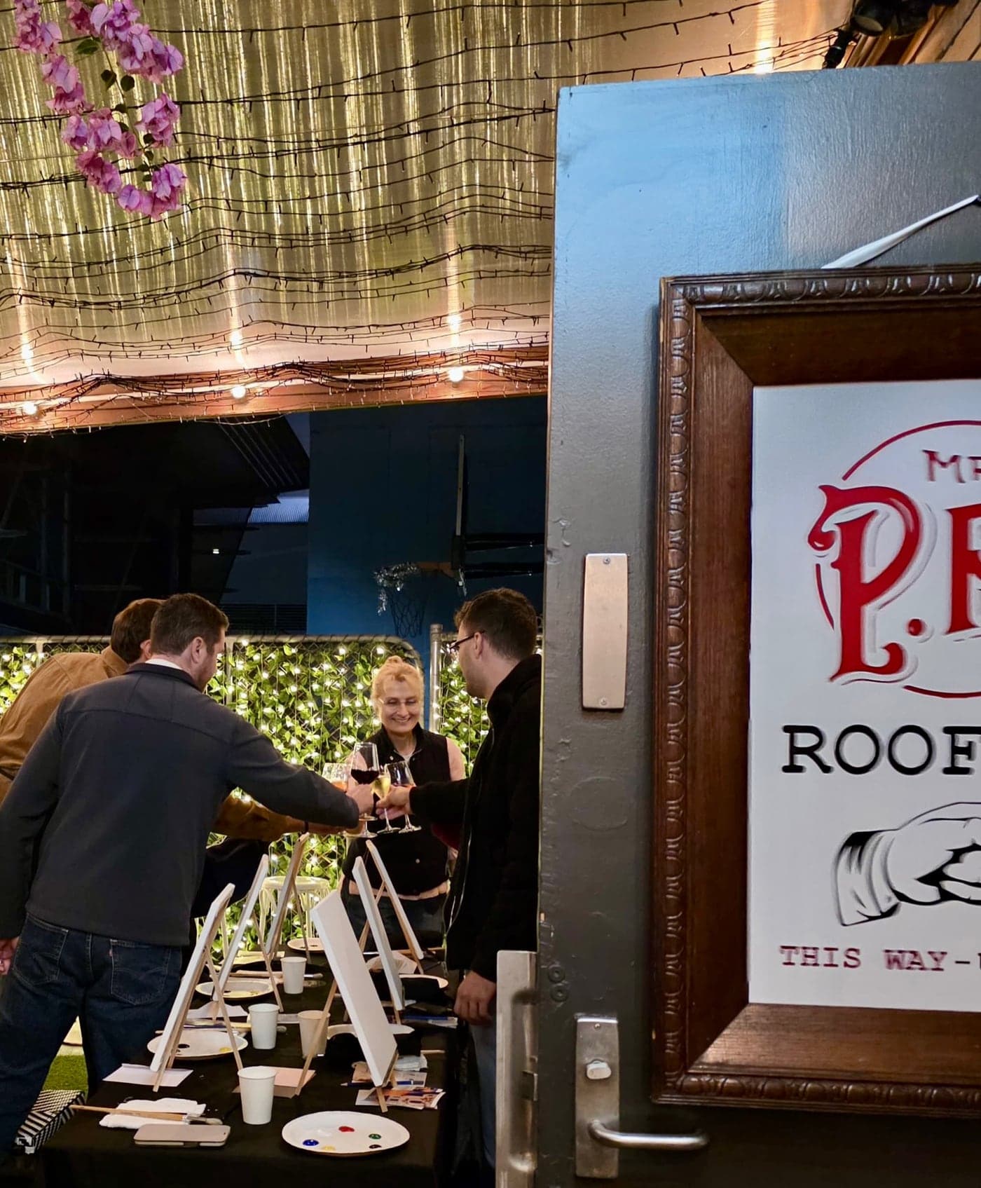 Guests at a long table of easels at Mr PP's rooftop.