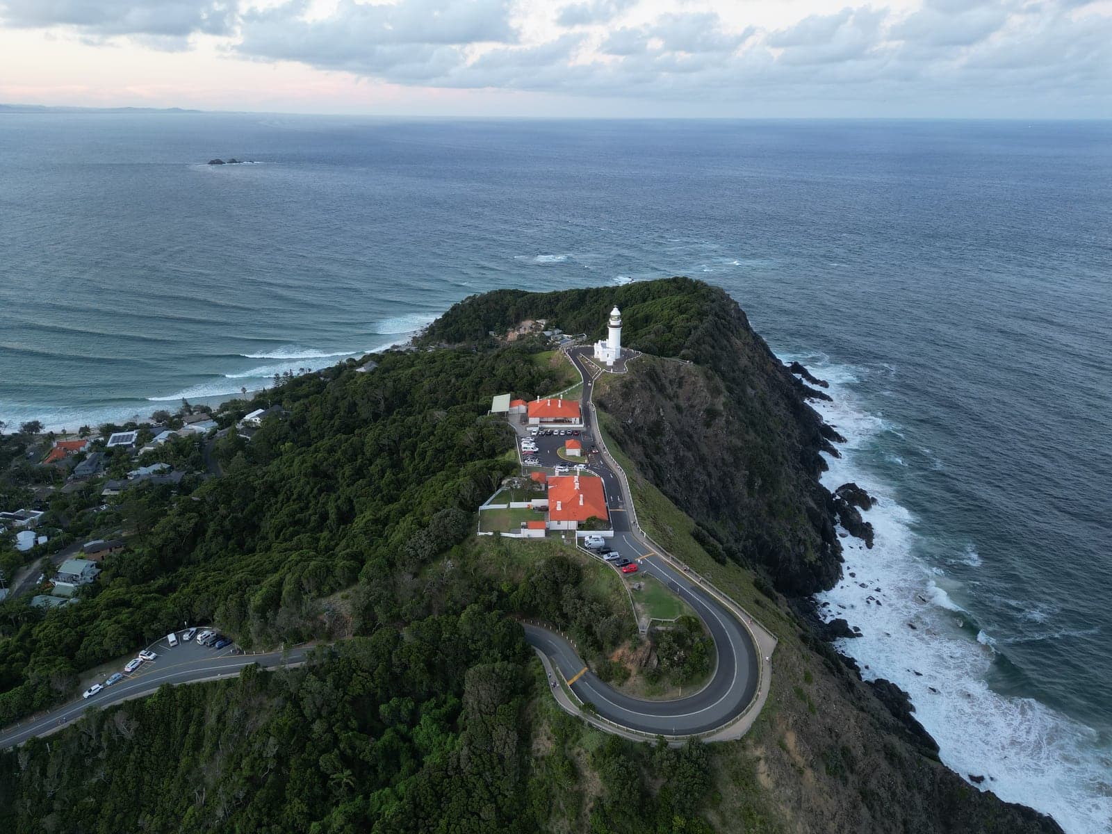 El faro de Cape Byron sobre el cabo, con el camino subiendo entre el bosque.