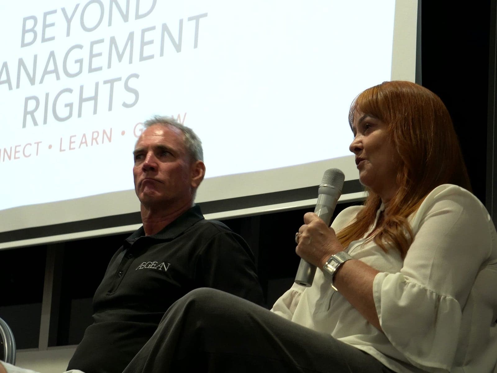 Panelistas en el escenario frente a la pantalla de Beyond Management Rights.
