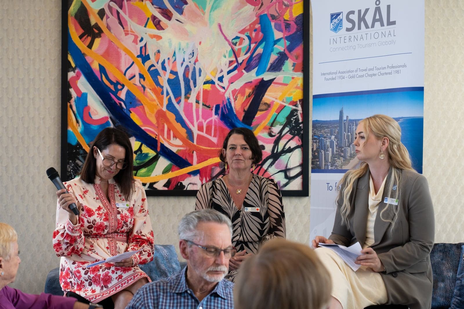 Tres panelistas frente a un banner de Skål.