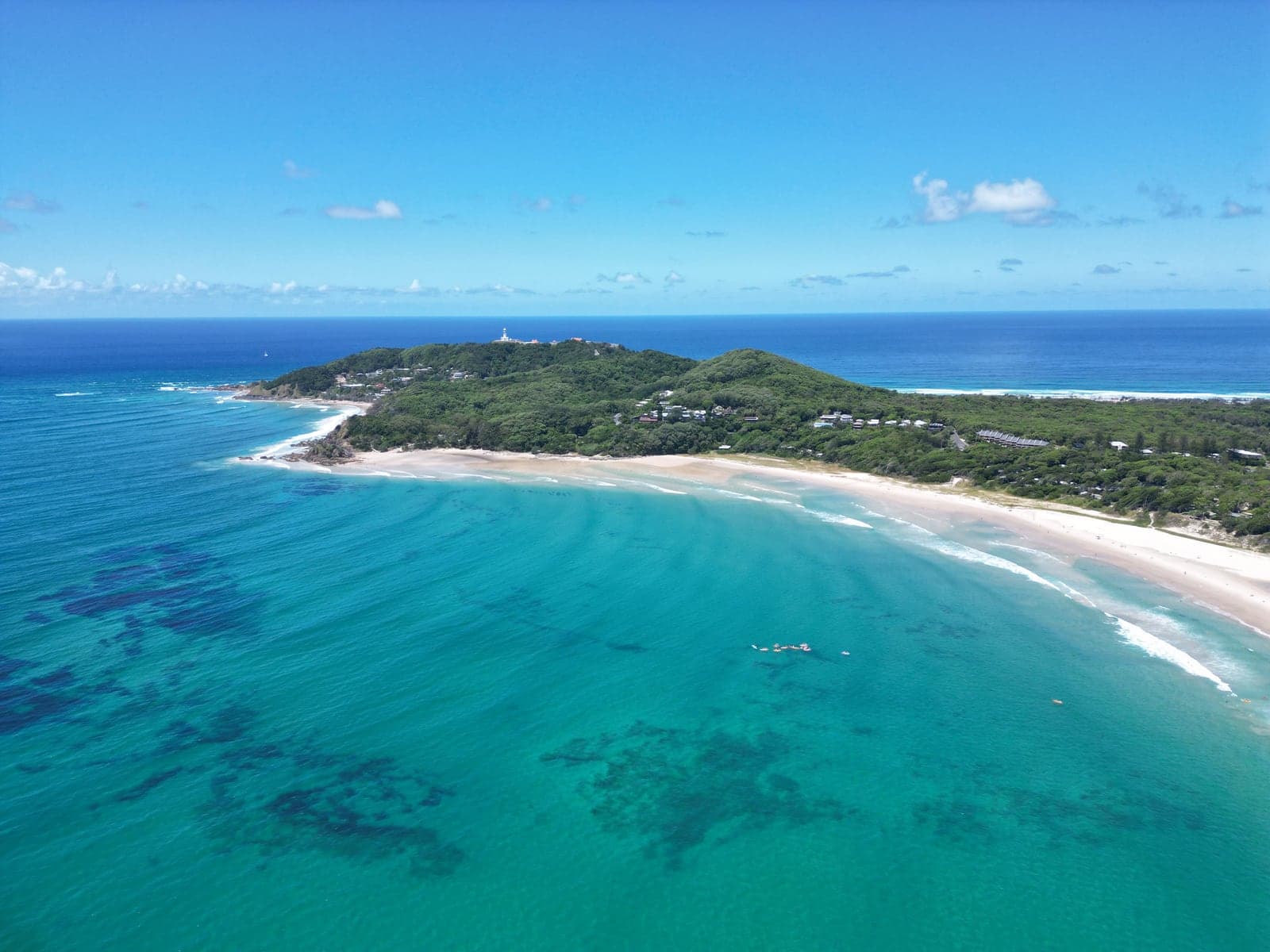 Agua turquesa y el cabo en Byron Bay.