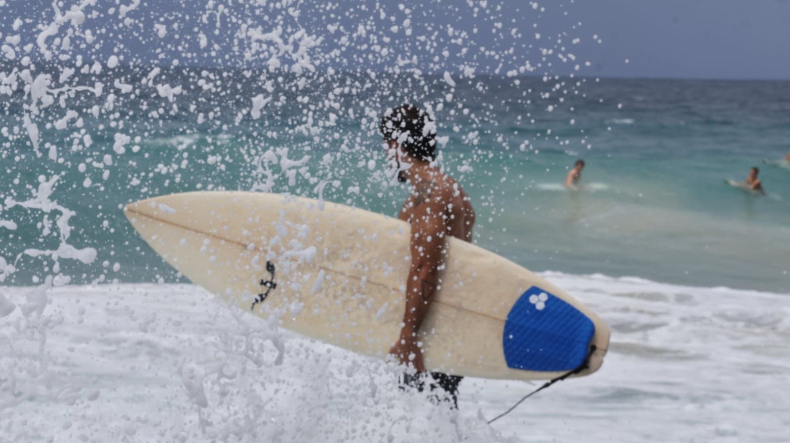 Un surfista atravesando la espuma con su longboard.