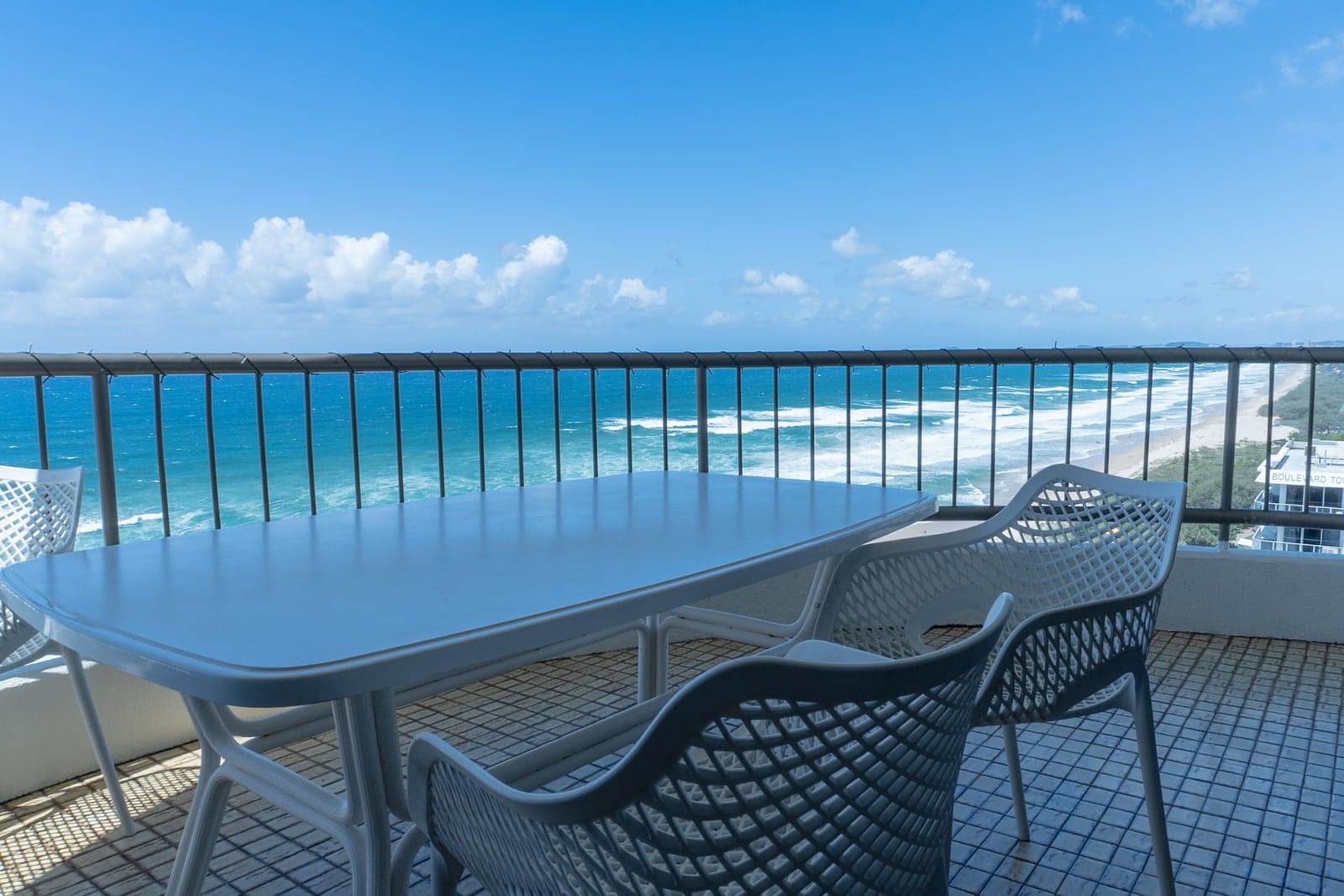 Una mesa de balcón sobre la costa, con la playa extendiéndose hasta el horizonte.