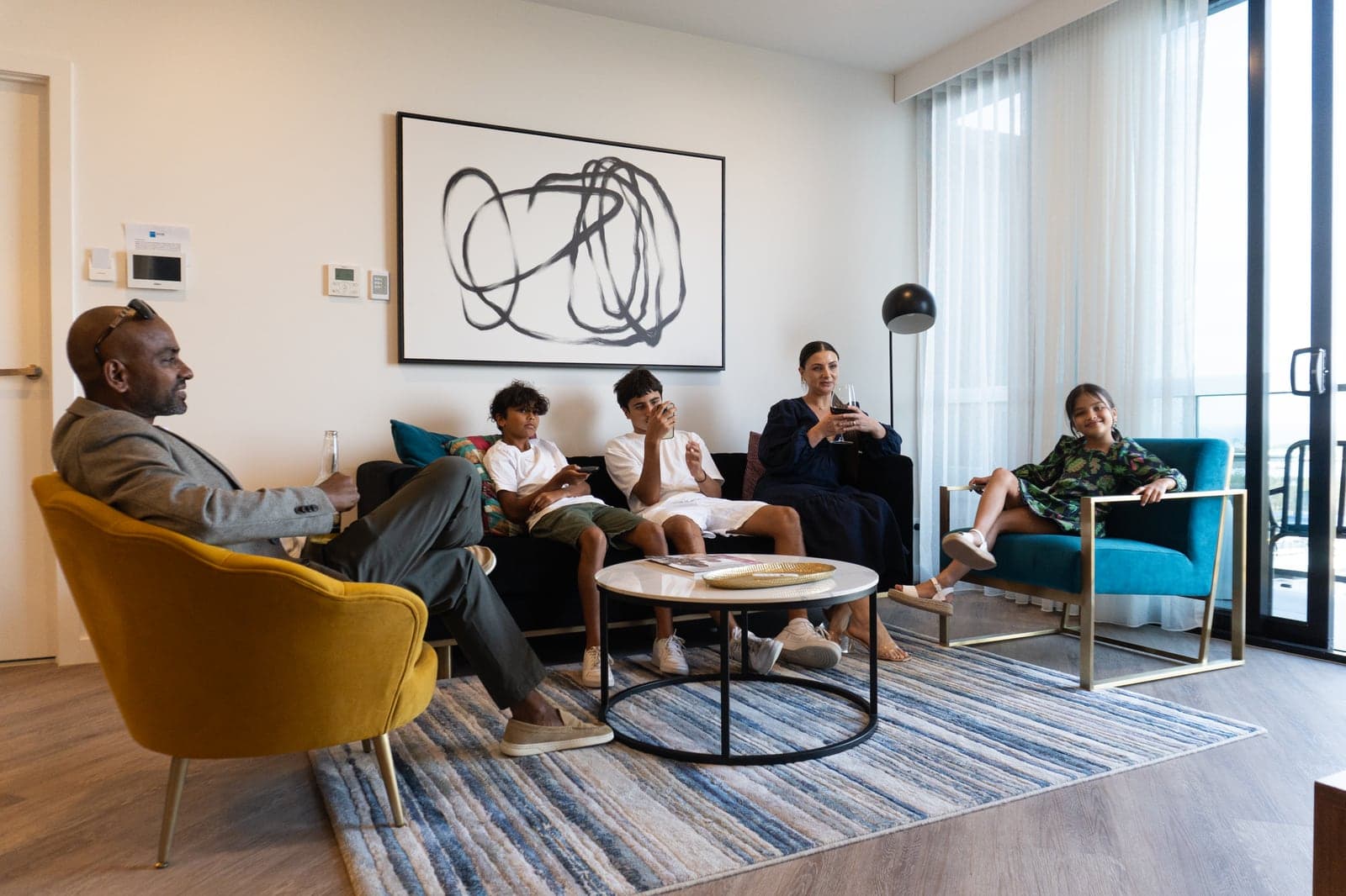 Una familia descansando en el living de un departamento del TRYP Southport.